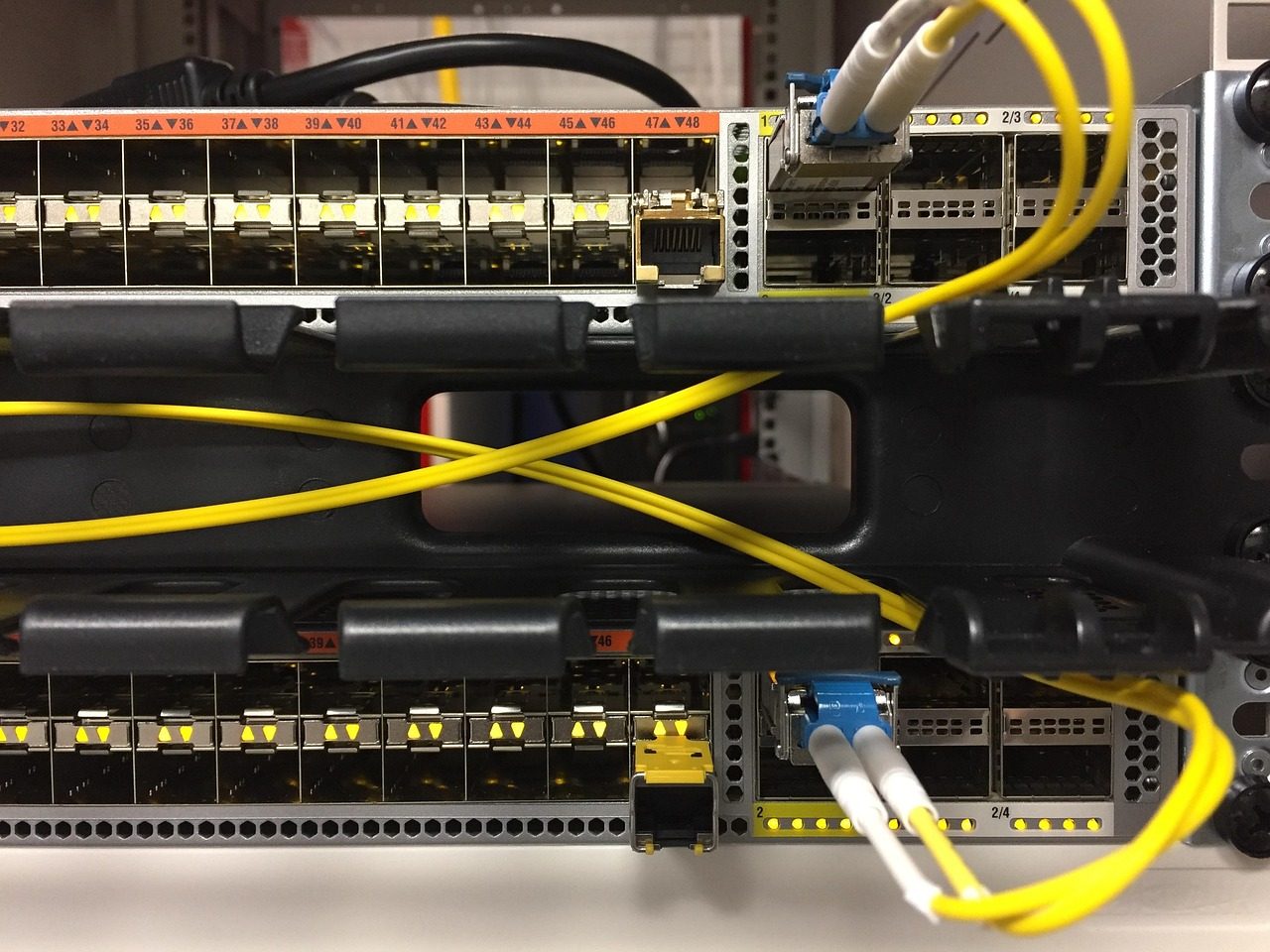 A network switch with fibre-optic and Ethernet cables plugged in