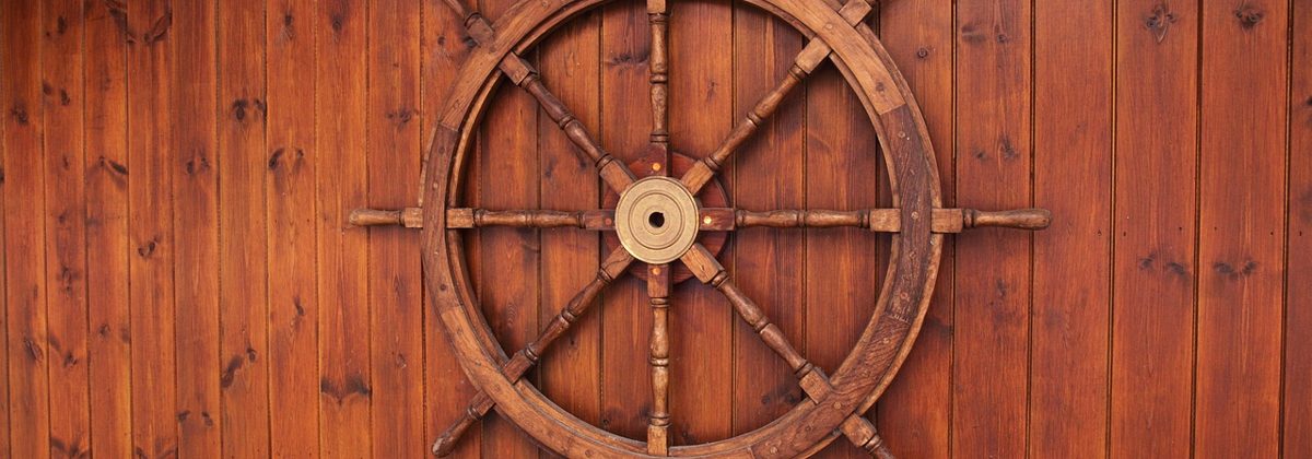 Una vecchia ruota del timone di una nave in legno, il timone